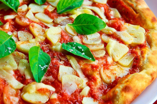 Frisch gebackene Pizza mit Tomatensauce, Käse und Basilikum von Pizza Engersdorf